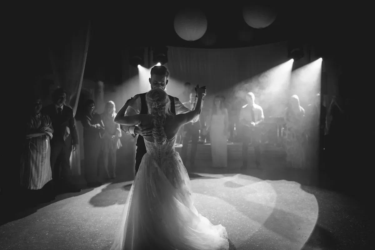 Bride and groom dancing under spotlights at an indoor wedding reception